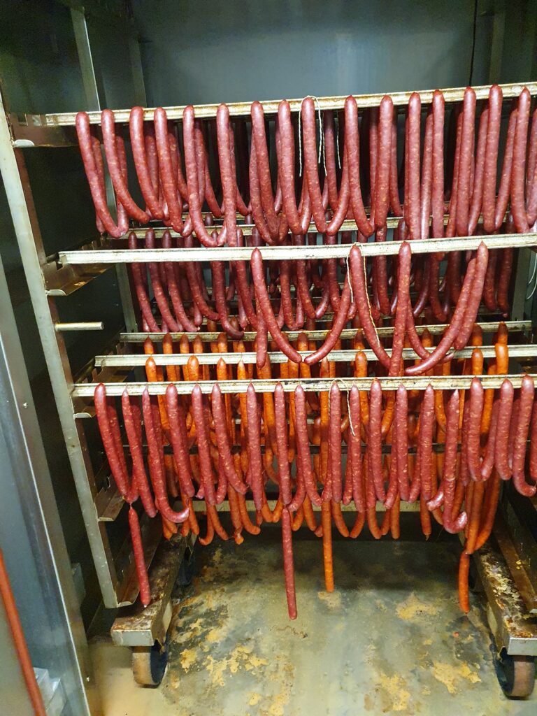 Frisch geräucherte Mettwürste auf dem Räucherwagen